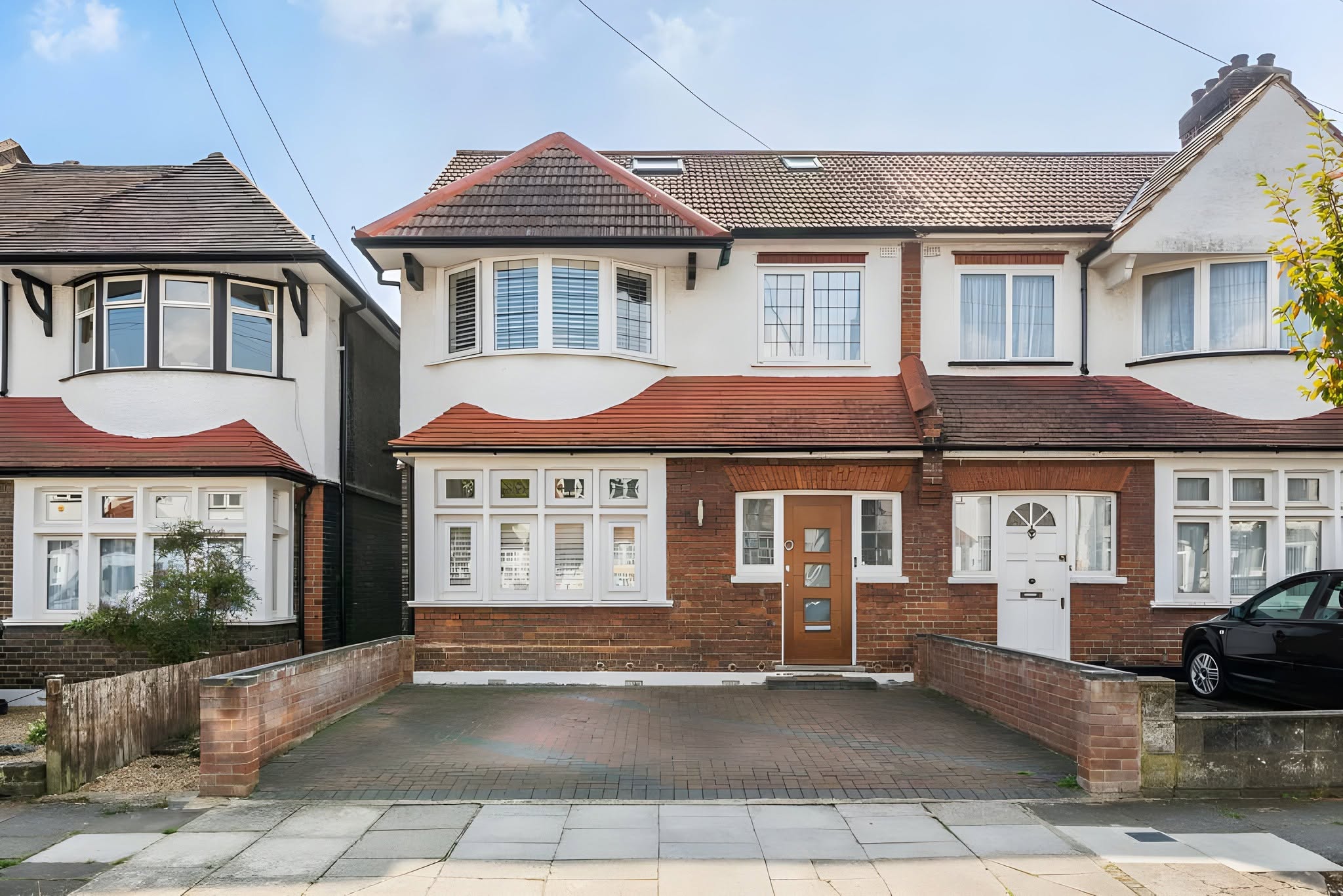 Renovated front exterior with a clean paved driveway