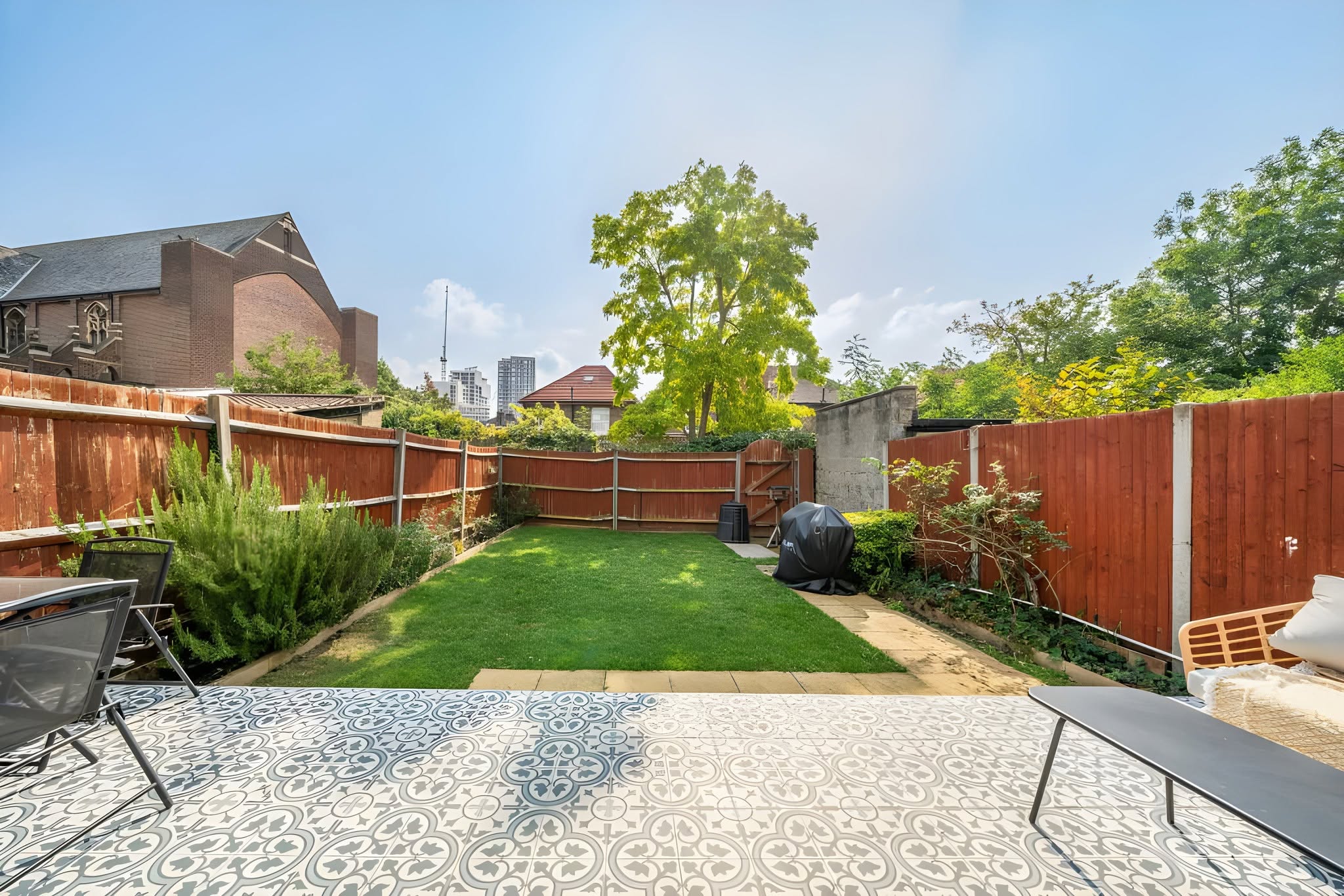 Landscaped garden with lawn, planting and patterned patio